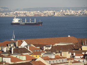 Large ship on the sea, surrounded by city and red roofs, Lisbon, portugal