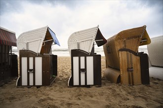 Roofed wicker beach chairs at the baltic sea beach, coast at the island of Usedom in Germany, storm