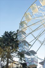 Ferris wheel on the blue sky background. Attraction present in amusement parks