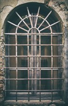Ancient medieval window with wrought iron bars