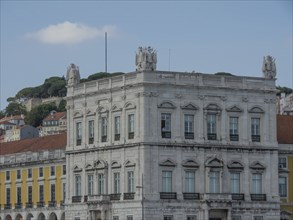 Symmetrical historical building with figures under a bright summer sky, Lisbon, portugal