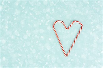 Candy cane forms heart shape, Christmas holiday background, winter season greeting card
