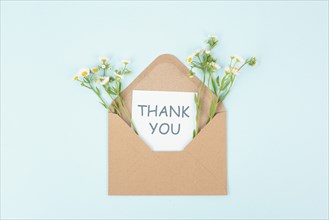 Thank you card in an envelope surrounded by flowers, being thankful, support, help and charity