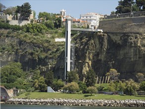 A cliff-top lift next to historic buildings on a green hill, Lisbon, portugal