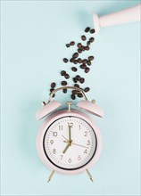 Wake up in the morning, time for breakfast, coffee break, alarm clock with roasted beans pouring