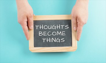 Thoughts become things is standing on a chalkboard, positive thinking and motivation concept,