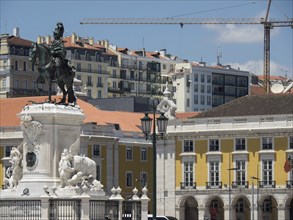 A monument with an equestrian statue on a square, surrounded by historic buildings and construction