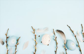 Easter eggs with willow branches and bird feathers, holiday greeting card, spring season background