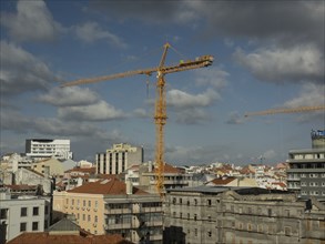 City view with several construction cranes and buildings under a cloudy sky, Lisbon, portugal