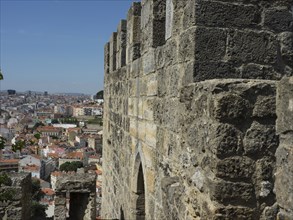 Medieval stone wall of a castle with a view of the city and the houses, Lisbon, portugal
