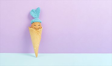 Cute easter bunny or rabbit with a smiling egg face in an ice cream cone, spring holiday, greeting