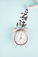 Wake up in the morning, time for breakfast, coffee break, alarm clock with roasted beans pouring