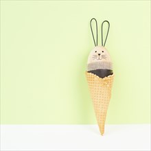 Cute easter bunny or rabbit in an ice cream cone, spring holiday, greeting card