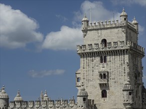 Close-up of a historic tower with architectural details under a blue sky with clouds, Lisbon,