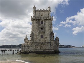 Historic tower in a body of water under a cloudy sky, Lisbon, portugal