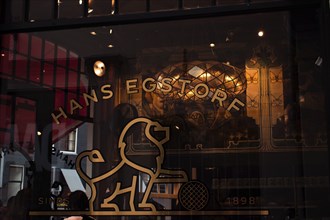 Retro shop window with gold-coloured lion emblem, stylised windows and ornate vintage-style