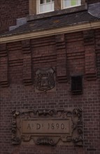 Historic brick façade of a building, built in 1890, decorated sign and relief, Amsterdam,