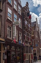 Historic hotel building in a city with brick façade with various flags, Amsterdam, Netherlands