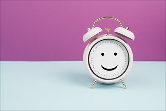 Happy face on an alarm clock, mental health concept, positive emotion and mindset