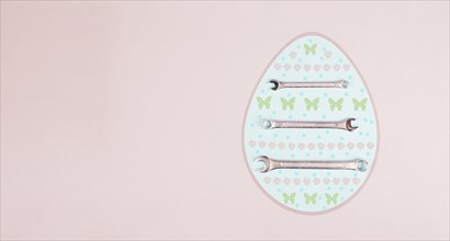 Easter egg with wrenches and butterflies, holiday greeting card with repair tools, spring season