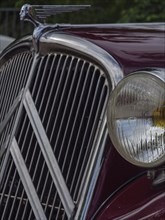 Front view of a red vintage car with striking radiator grille and detailed emblem, winterswijk,