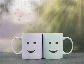 Happy, similing face, mug couple on a window sill cuddle, cup of coffee on a rainy day, support,