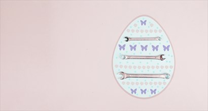 Easter egg with wrenches and butterflies, holiday greeting card with repair tools, spring season