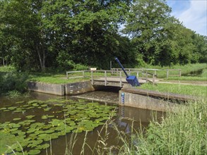 A bridge over a river, surrounded by water lilies and green banks, lichtenvoorde, gelderland, the