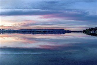 Lake Kochel with reflection of sun and clouds at sunset, calm water, Kochel am See, Bavarian