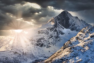 Snow mountain landscape near Tromso, norway during sunrise with cloudy sky