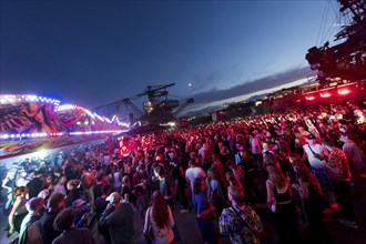 Festival visitors celebrate between excavators at the Melt Festival in Ferropolis on 12 July 2024.