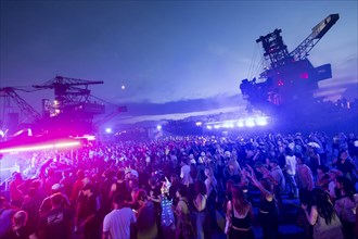 Festival visitors celebrate between excavators at the Melt Festival in Ferropolis on 12 July 2024.