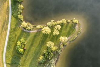 Aerial view of bathing area on small peninsula at lake Rottachsee with little hut, clouds are