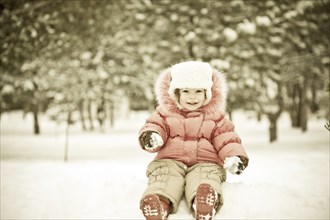 Child playing at snowballs in winter park