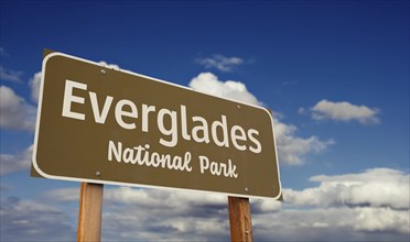 Everglades national park (florida) road sign against blue sky and clouds