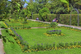 Visitors sunbathe in the flower beds in the courtyard garden, Kempten, Allgäu, Bavaria, Germany,