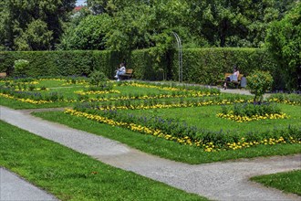 Visitors sunbathe in the flower beds in the courtyard garden, Kempten, Allgäu, Bavaria, Germany,