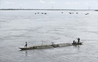 Labourer carries extracted sand from Beki River, in Barpeta district in Assam, India on Sunday