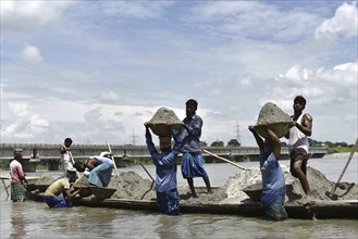 Labourer carries extracted sand from Beki River, in Barpeta district in Assam, India on Sunday