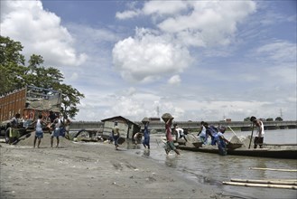 Labourer carries extracted sand from Beki River, in Barpeta district in Assam, India on Sunday