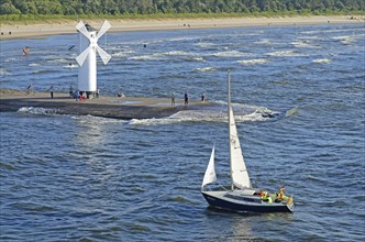 Sailboat passing the lighthouse when entering the port of Swinoujscie, Swinemünde, West Pomerania,