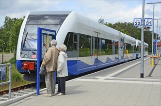 Two people look at the tour list at the local trains that serving Stralsund in Germany and