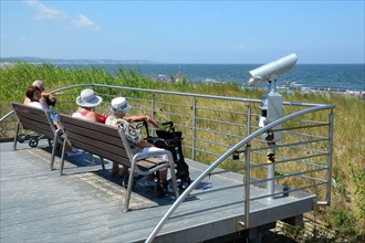 Elderly women sit on viewpoint by the beach to the Baltic Sea in Swinoujscie, Swinemünde, West