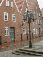 Quiet old square with brick houses and historic lanterns on cobblestones, stade, germany