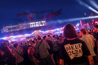 Festival visitors celebrate between bumper cars and excavators at the Melt Festival in Ferropolis