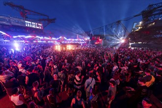 Festival visitors celebrate between excavators at the Melt Festival in Ferropolis on 12 July 2024.