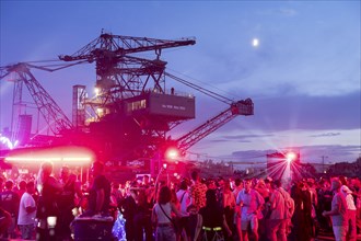 Festival visitors celebrate between excavators at the Melt Festival in Ferropolis on 12 July 2024.