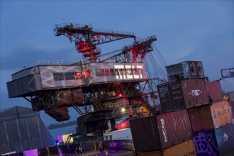 Opencast mining excavators behind containers at the Melt Festival in Ferropolis on 12 July 2024.