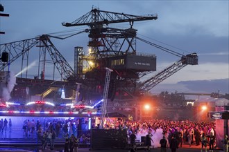 Festival visitors celebrate between excavators at the Melt Festival in Ferropolis on 12 July 2024.