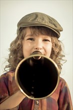 Kid shouting through vintage megaphone. Communication concept. Retro style